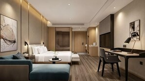 A modern hotel room with a bed, a desk, a chair, a sofa, and a TV. - Jindu Hotel (Gucheng)