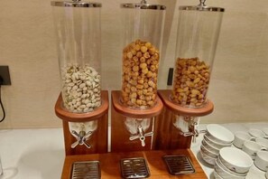 Trois distributeurs contenant différents types d’aliments, un plateau avec des assiettes et une prise de courant murale.