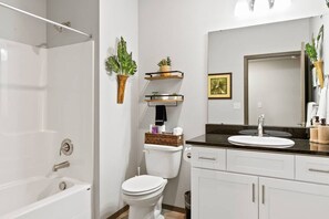 Bathtub, hair dryer, towels, toilet paper