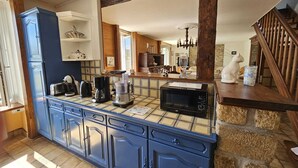 Een keuken met een blauwe kast, een magnetron en een koffiezetapparaat op het aanrecht.