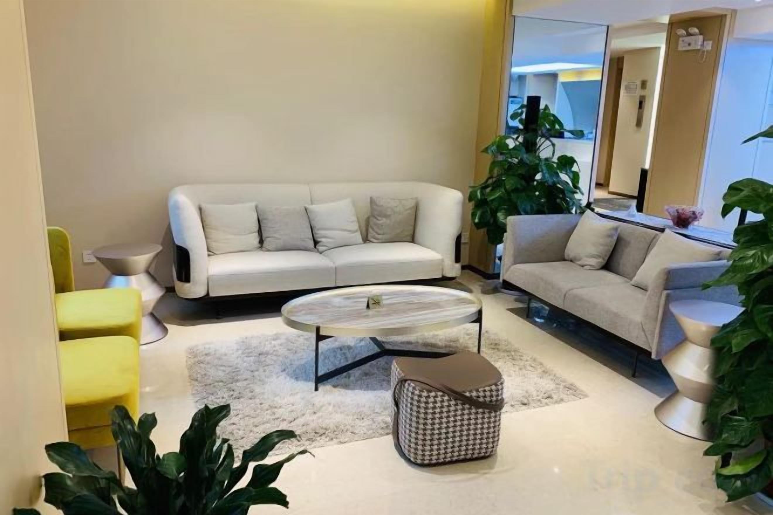 A modern living room with a sofa, coffee table, and chairs.