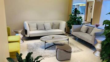 A modern living room with a sofa, coffee table, and chairs.