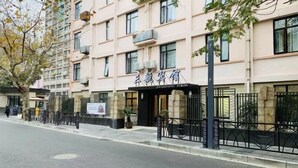 Un hôtel de style architectural traditionnel, doté de nombreuses fenêtres et d’une entrée fermée par un portail.