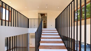 A modern staircase with wooden steps and black railings, leading to an upper floor. - Mawün Hotel Pucón (Pucón)