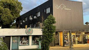 A modern building with a sign for MAHÜN hotel, featuring a minimalist design with vertical wooden slats and a flat roof. - Mawün Hotel Pucón (Pucón)