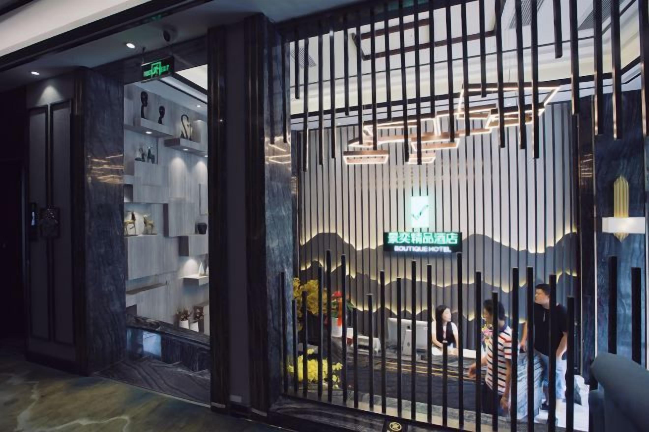 Entrada de um hotel boutique com design moderno, destacando a recepção e uma placa visível.