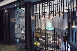 A boutique hotel entrance with a modern design, featuring a reception desk and a visible sign. - Jingyi Boutique Hotel (Shimian)