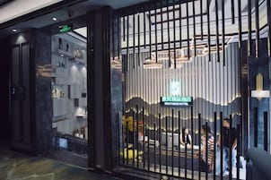 Entrada de un hotel boutique con diseño moderno, que presenta una recepción y un letrero visible.