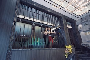 A modern interior with a large window, a staircase, and a decorative vase.
