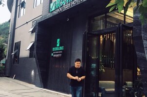 Entrada de un hotel boutique con diseño moderno, una recepción y un número de teléfono visible.