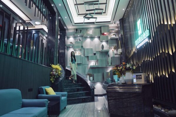 A modern hotel lobby with a staircase, seating area, and reception desk. - Jingyi Boutique Hotel (Shimian)