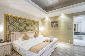 A hotel room with a large bed, a nightstand, a wall clock, and a door leading to a bathroom. - Mei Di Ya Zhong Hua Hotel (Zhuolu)