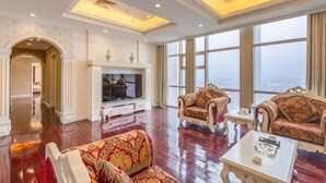 A spacious living room with a fireplace, large windows, and elegant furniture.