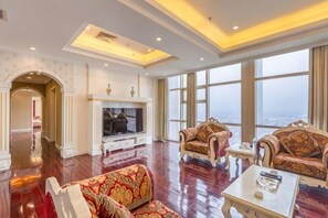 A spacious living room with a fireplace, large windows, and a high ceiling. - Mei Di Ya Zhong Hua Hotel (Zhuolu)