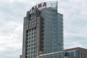 A high-rise building with multiple floors and a prominent sign at the top.