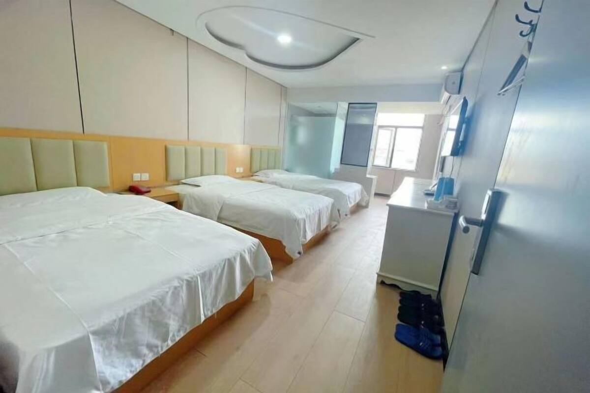 Una habitación de hotel con dos camas, un escritorio y un armario.