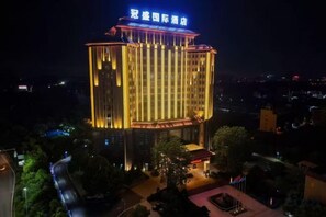 A multi-story hotel with a prominent sign at the top. - Guansheng International Hotel (Puning)