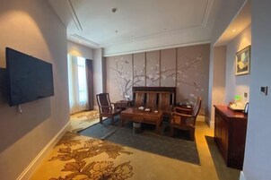 Una habitación de hotel con decoración interior de estilo japonés tradicional, que incluye suelo de tatami, una mesa de madera baja y un conjunto de sofás.