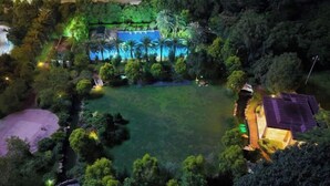 Eine Vogelperspektive auf ein Resort mit Schwimmbad, Palmen und einer Solaranlage.