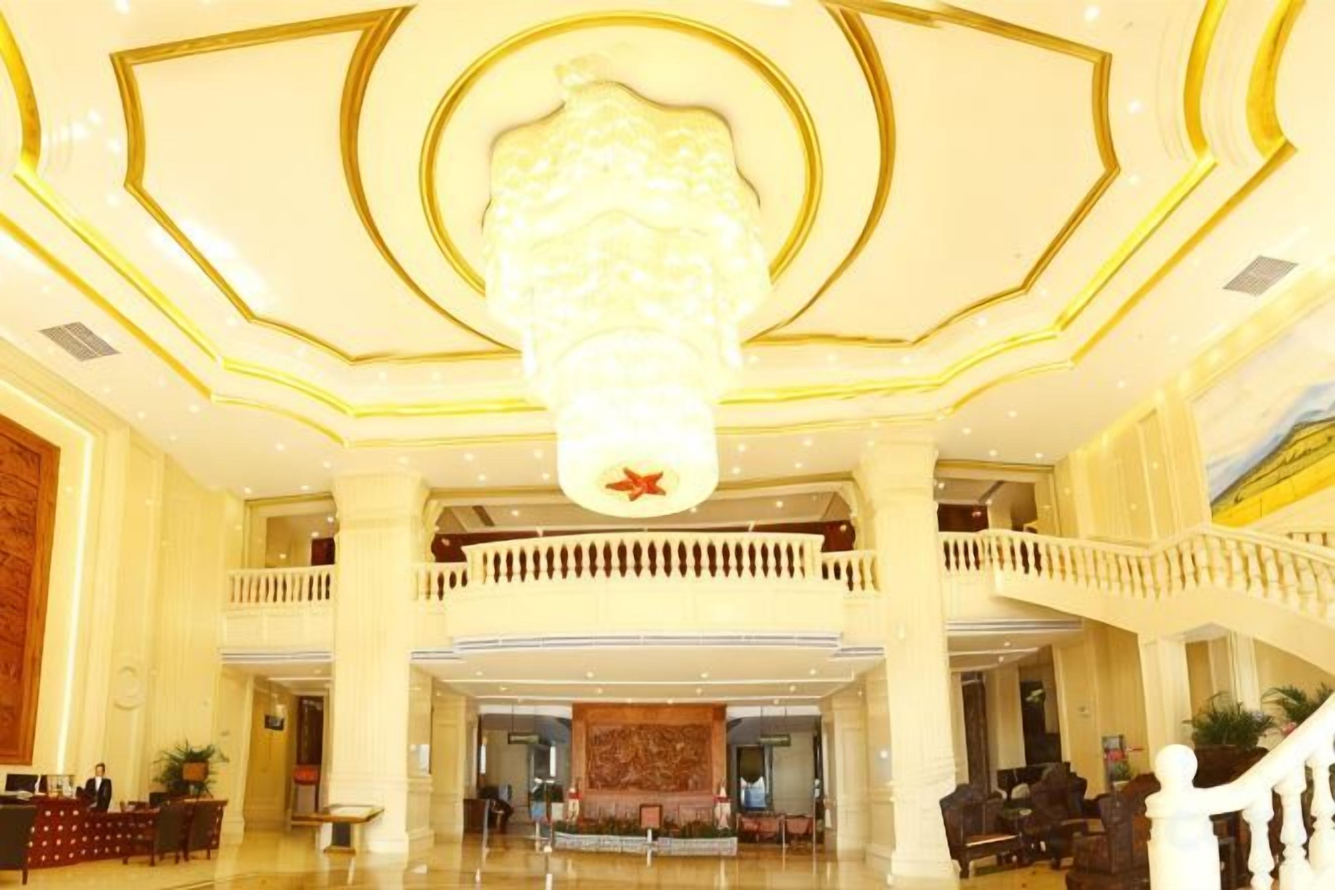 Eine Lobby mit einem prächtigen Kronleuchter, einem Empfangstresen und einem Balkon.