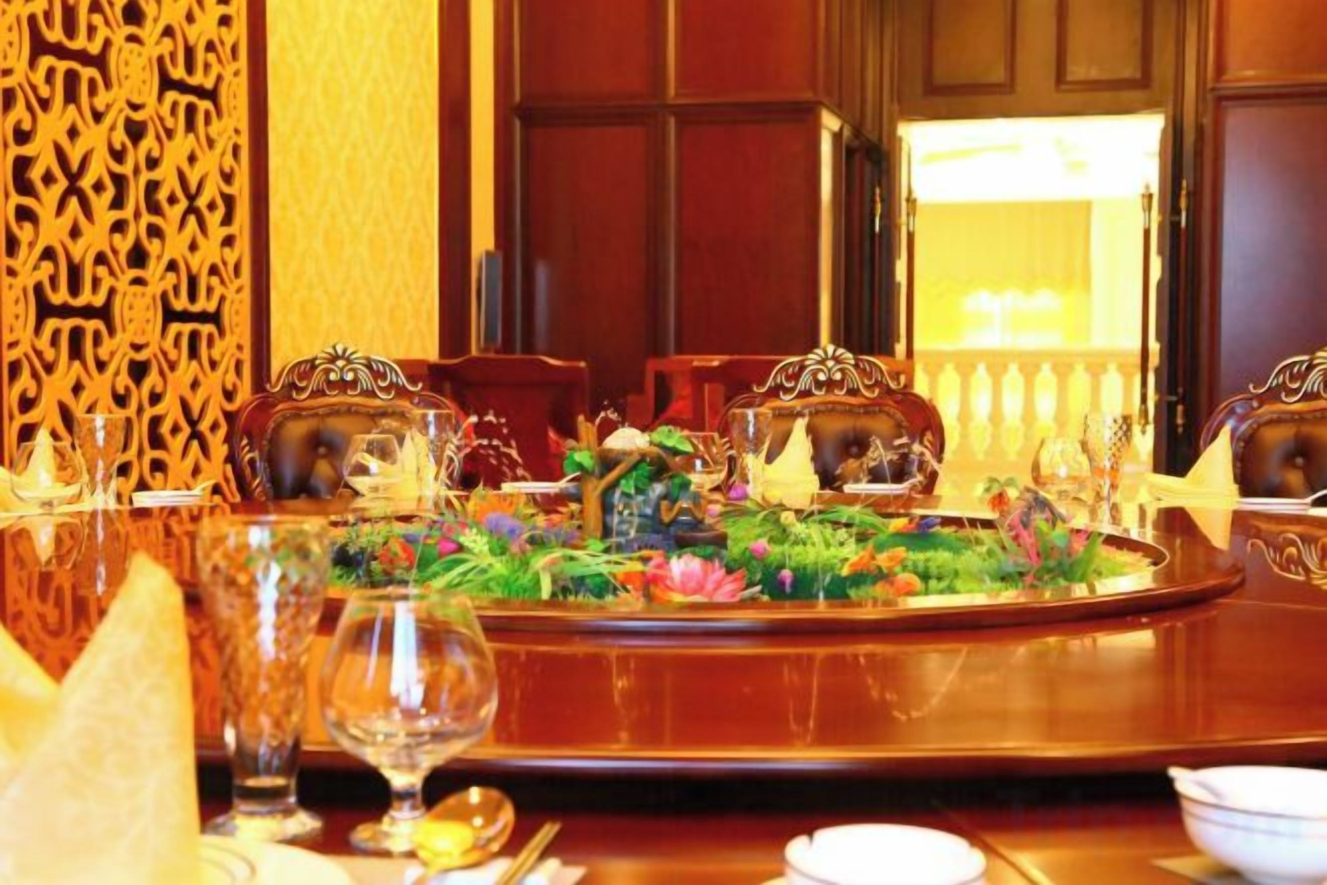 A dining table set with a floral centerpiece, surrounded by ornate chairs.
