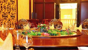 A dining table set with a floral centerpiece, surrounded by ornate chairs.