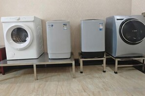 Three appliances on a table: a washing machine, a refrigerator, and a dryer. - Shenzhen Bolang Hotel (Xintangwei Metro Station) (Shenzhen)