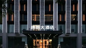 A modern hotel entrance with a prominent sign, large windows, and a symmetrical facade. - Shenzhen Bolang Hotel (Xintangwei Metro Station) (Shenzhen)