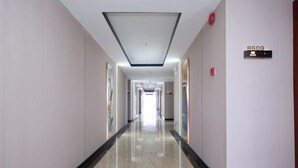 A long, well-lit hallway with a marble floor, a ceiling light, and a door with a sign indicating room number 8609. - Shenzhen Bolang Hotel (Xintangwei Metro Station) (Shenzhen)