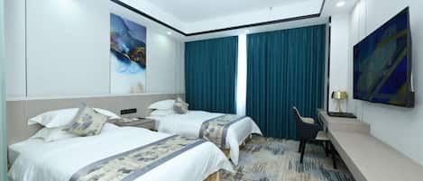 Quarto de hotel com duas camas, uma escrivaninha, uma cadeira e obras de arte nas paredes.