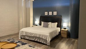 A bedroom with a bed, two bedside tables with lamps, a patterned rug, and a wooden floor. - 424 Gold Way- 3Bed/2Bath Apartment (Pittsburgh)