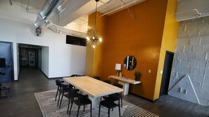 A modern conference room with a wooden table, black chairs, a white desk, and a round mirror on the wall. - 424 Gold Way- 3Bed/2Bath Apartment (Pittsburgh)