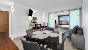 A modern apartment with a dining area, kitchen, and a balcony with a city view. - Monthly Discovery Bay 1902 2 Bd  Ocean Views/ High Floor / 2x Queen Beds+Sofa Bed (Honolulu)