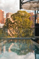 A modern pool area with a clear view of surrounding buildings and trees.