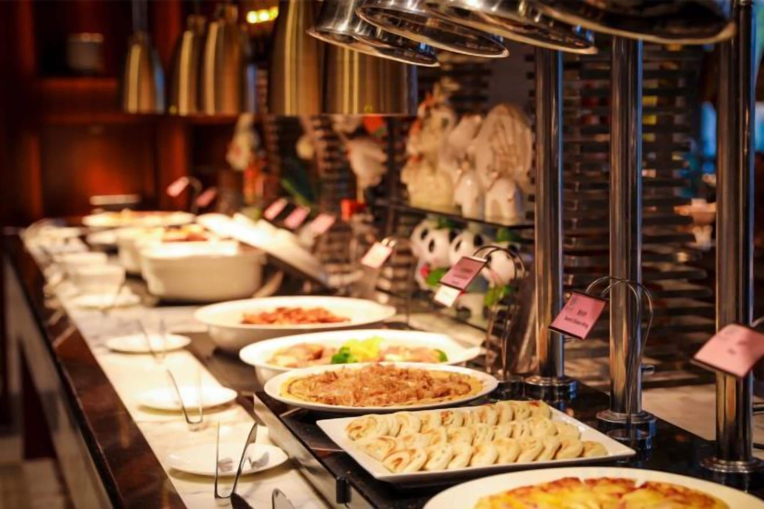 A buffet with various dishes and a sign indicating the price.