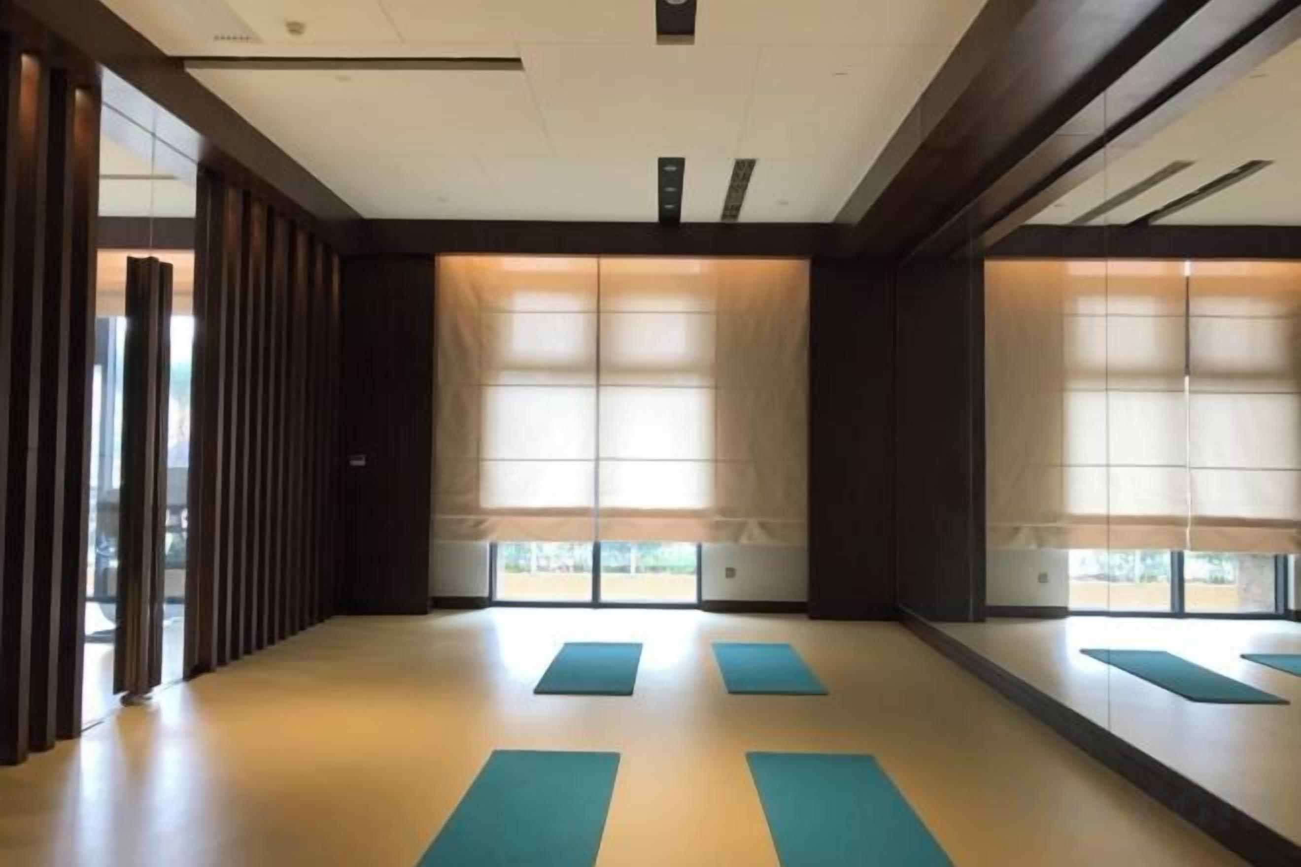 A room with tatami mats, sliding doors, and large windows.