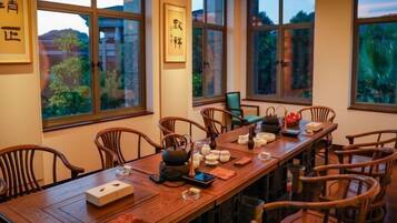 Comedor tradicional con una larga mesa de madera dispuesta para una comida, rodeada de sillas de madera.