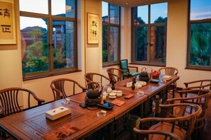 Een traditionele eetkamer met een lange houten tafel, gedekt voor een maaltijd, omringd door houten stoelen.