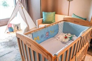 Ein Babybett mit blauem Lattenrost und Holzrahmen.