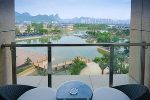 Un balcón con vista a un río, un puente y edificios al fondo.