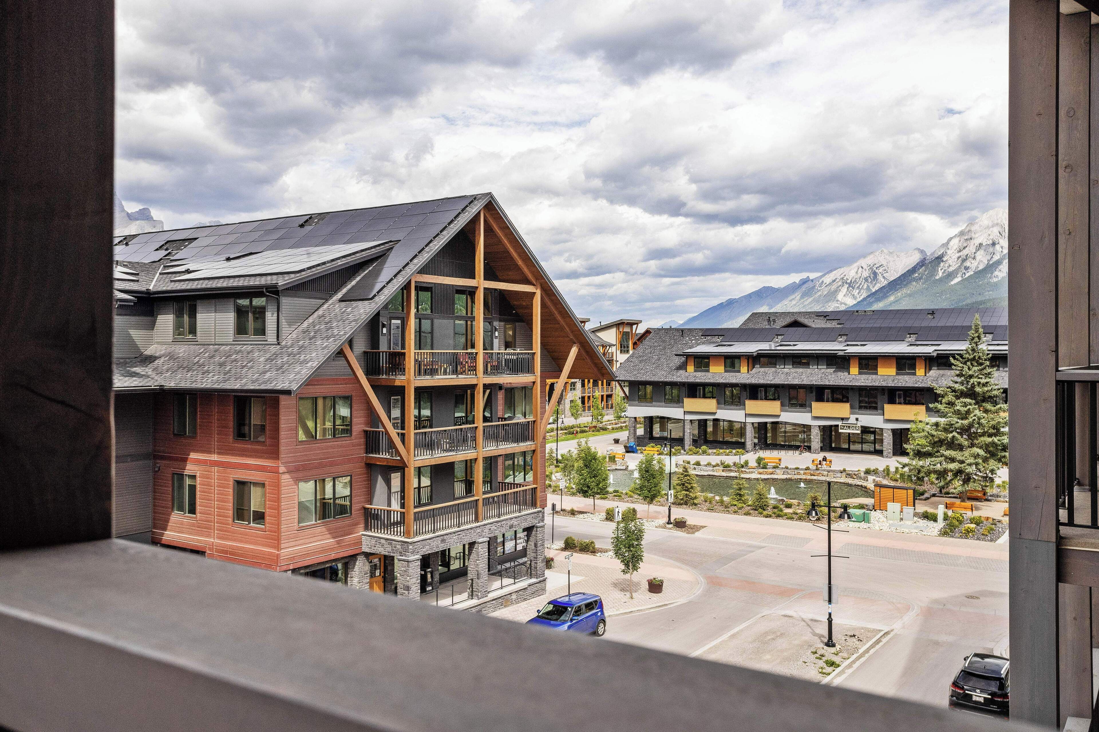 A modern building with multiple floors, large windows, and a prominent wooden structure.