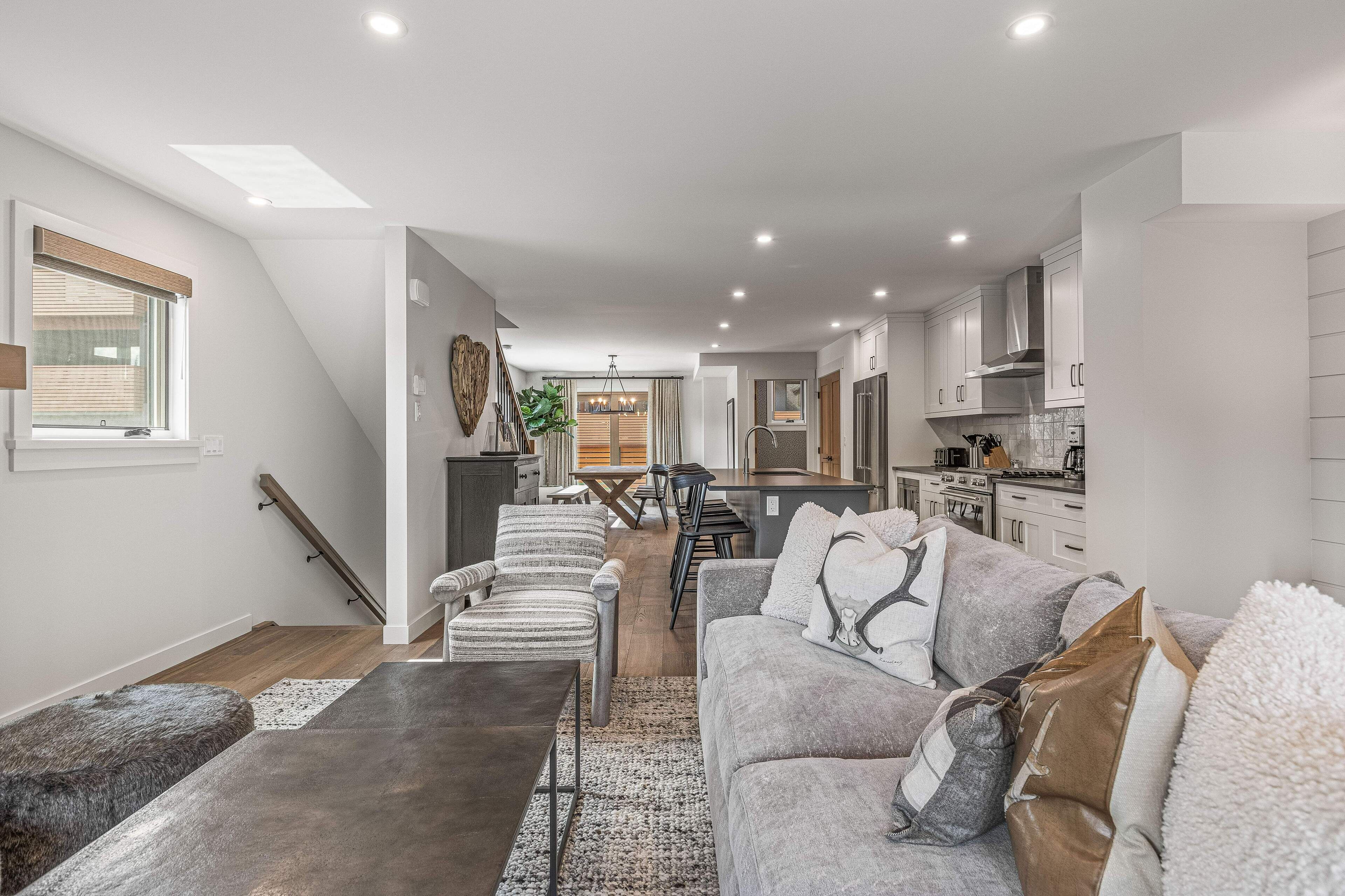 Un intérieur moderne avec un escalier menant à une chambre en mezzanine, un coin repas et une cuisine.