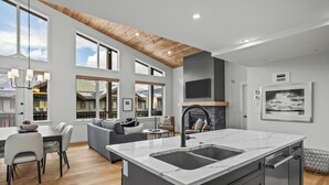 A modern kitchen with a large island, built-in appliances, and a fireplace.