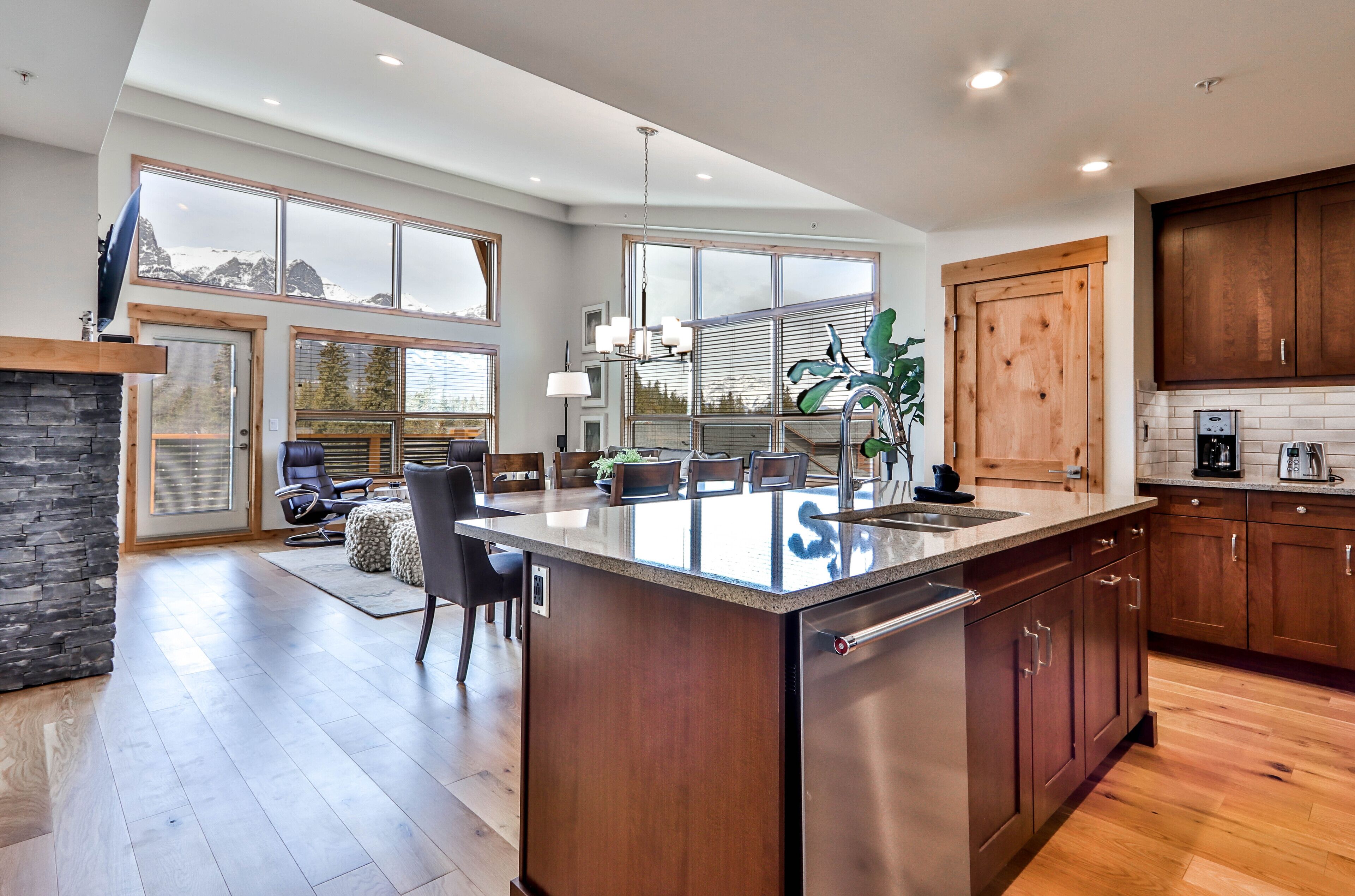 Una cocina amplia con una isla grande, armarios de madera y una chimenea de piedra.
