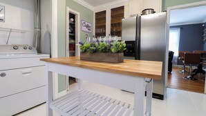 Cocina con encimera de madera, refrigerador de acero inoxidable y letrero que indica barra de café.