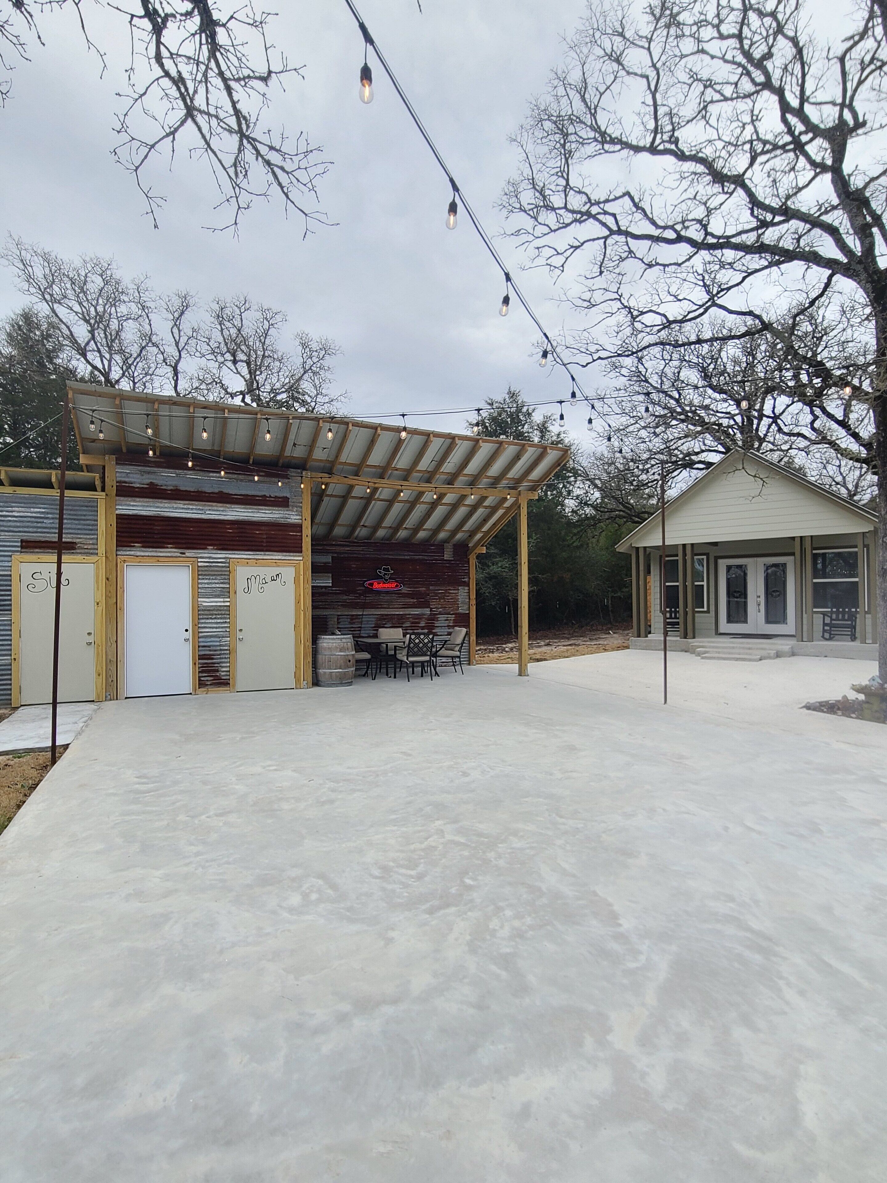 Un bâtiment de style rustique doté d’un patio couvert, d’un bar et d’une petite structure adjacente.