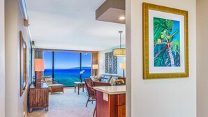 Una habitación con vista al océano, un comedor y un cuadro en la pared.