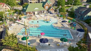 A swimming pool with multiple lanes, surrounded by lounge chairs and umbrellas. - Beautiful Cabin located on the Betsie River and close to Crystal Mountain Resort (Thompsonville)