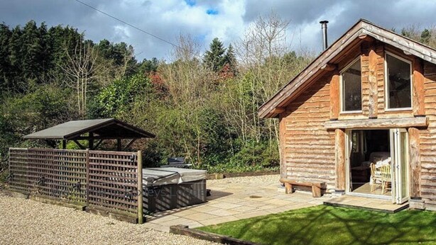 A log cabin with a covered patio and a small outdoor seating area. - Secluded, rural retreat nestled in Sherwood Forest, with hot tub (Newark)