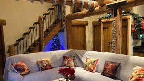 A cozy living room with a wooden staircase, a Christmas tree, and a sofa with festive pillows. - Secluded, rural retreat nestled in Sherwood Forest, with hot tub (Newark)